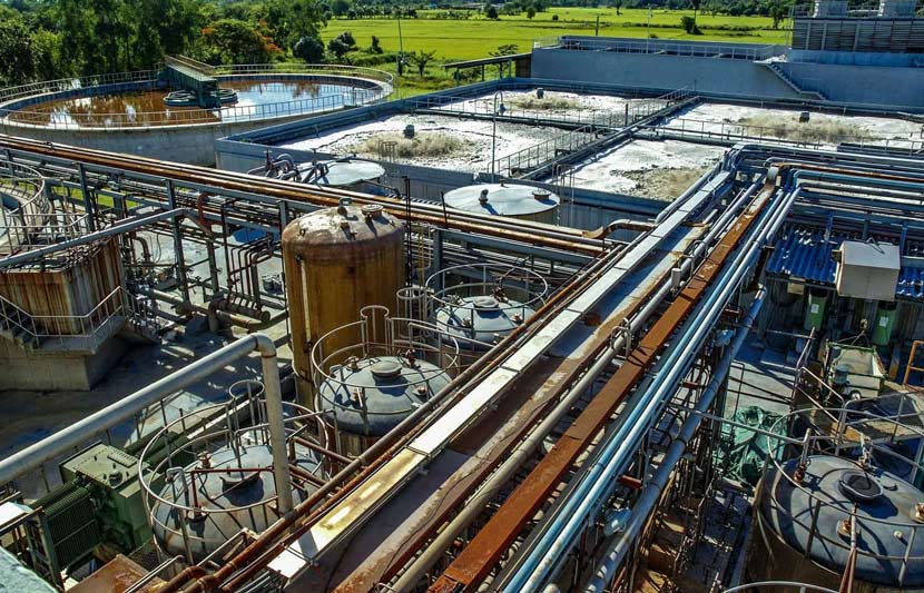 Industrial wastewater treatment plant with tanks and pipes, highlighting odour control for successful treatment processes.