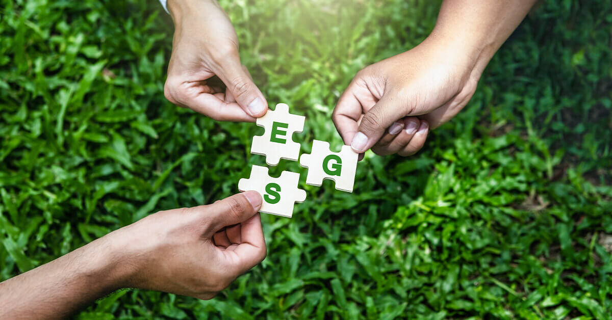 Three hands holding puzzle pieces with "ESG" letters, symbolizing sustainability and environmental goals.